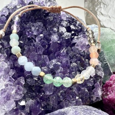 Zbliżenie bransoletki z siedmiu kamieni w srebrnych detalach.