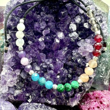 Zbliżenie bransoletki Energii Czakr w złotych detalach.