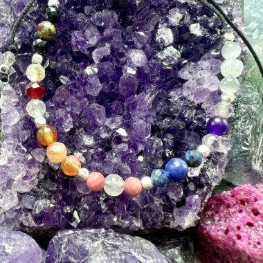 Zbliżenie bransoletki Pełni Energii Czakr w złotych detalach.