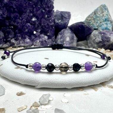 Bransoletka Tarcza Światła z czarnym sznurkiem i złotymi przekładkami.