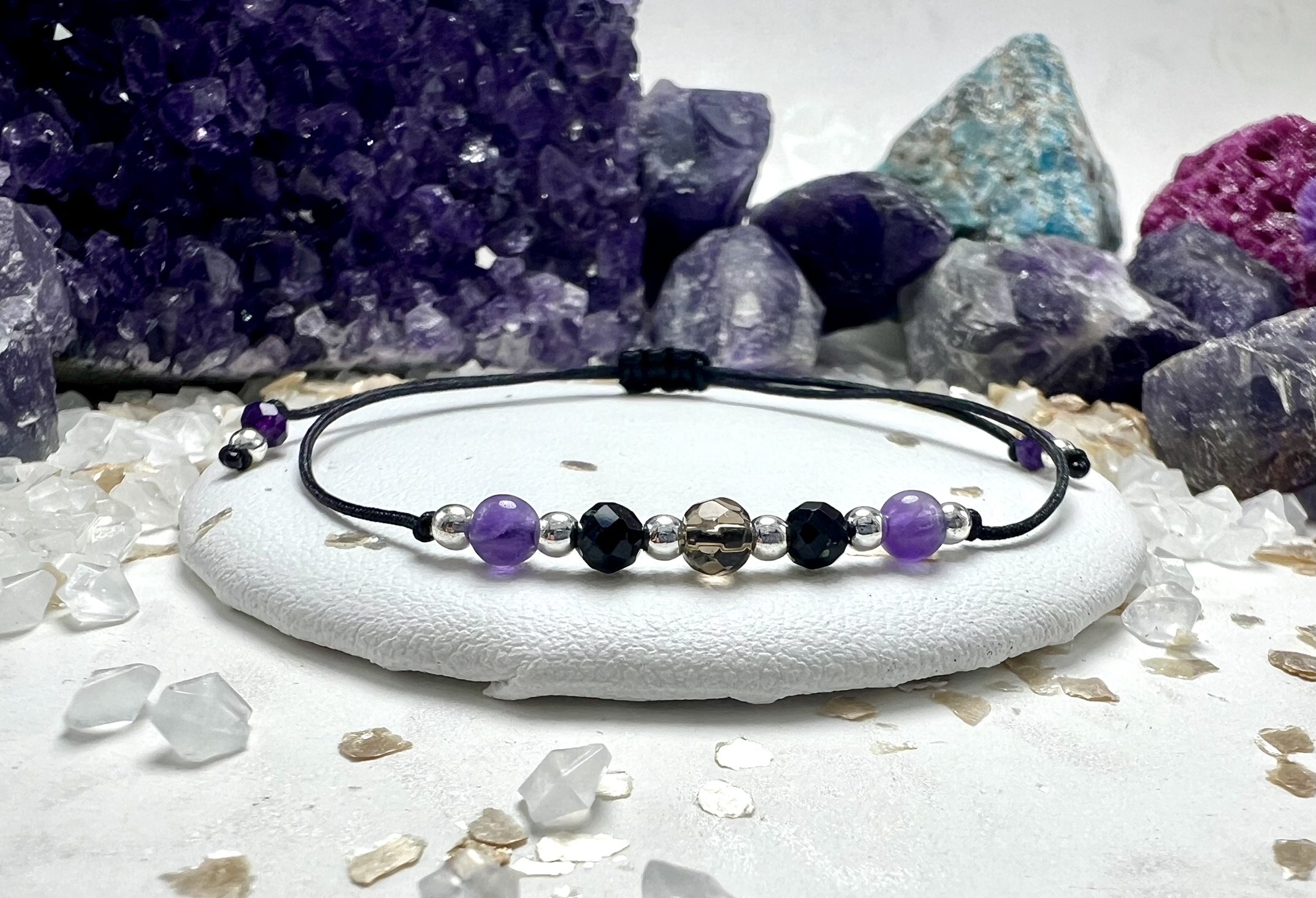 Bransoletka Tarcza Światła z czarnym sznurkiem i złotymi przekładkami.