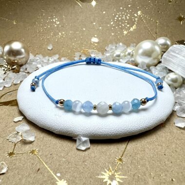 Małe opakowanie Moenii ze złotym logo i złotą wstążką.